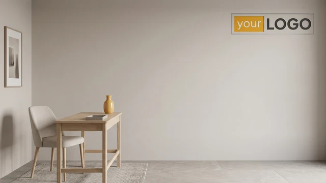 Minimal studio-style interior with light wood desk, upholstered chair, neutral wall, and framed logo creating a soft professional backdrop.